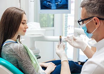 a dentist in Moses Lake explaining how dental implants work 