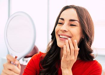 a woman smiling with her new dental implants