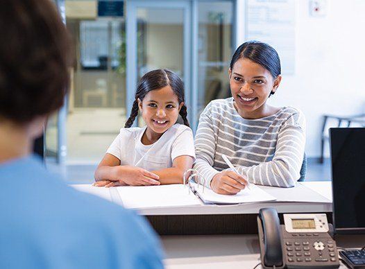 mother and daughter smiling at front desk