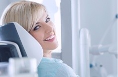 Woman in dental chair smiling over her shoulder