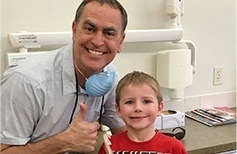 Moses Lake dentist giving thumbs up with young boy patient