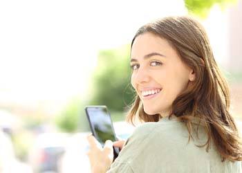 Closeup of woman smiling on her phone outside