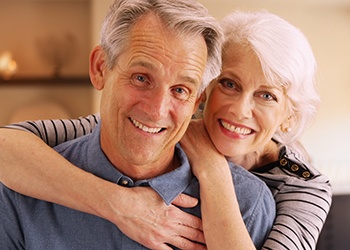 Older couple smiling in each other’s arms