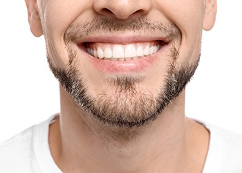 Close-up of a man’s smile with short stubble