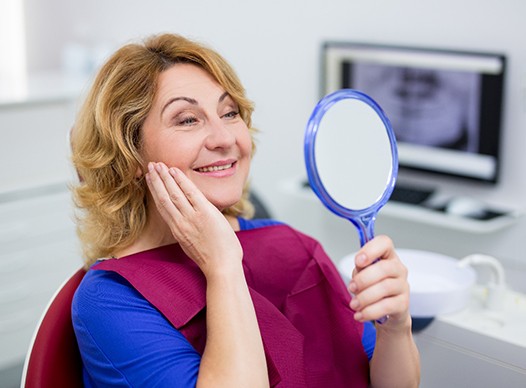 dental patient seeing her new smile with implant dentures in Moses Lake