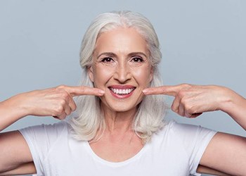 woman pointing to her smile