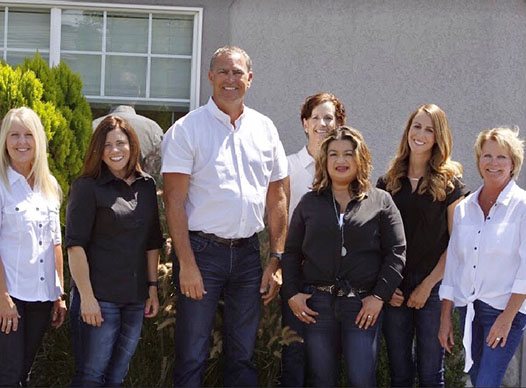 Dentist and dental team standing outside of Moses Lake Dentistry office building