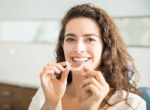 woman holding invisalign