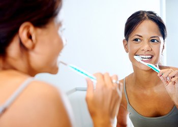 Woman brushing teeth in Moses Lake