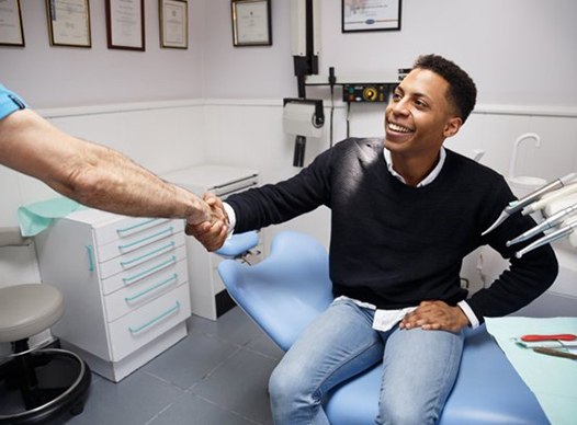 patient shaking his dentist’s hand 