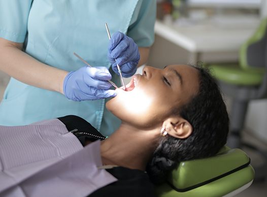 Woman having a dental procedure performed at dentist.