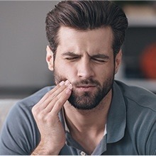 man holding jaw in pain