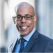 man in business suit and glasses smiling