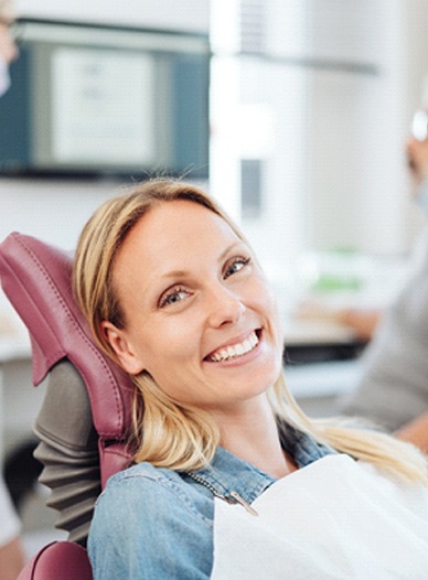 young woman smiling in the dentist chair after having a smile makeover