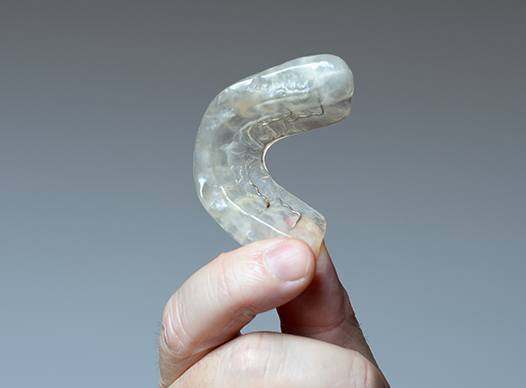 man holding occlusal splints