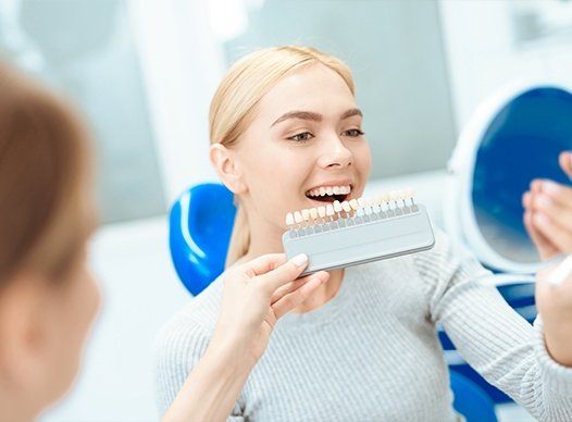 woman looking at veneers in circle mirror