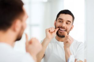 Man flossing using tips from a family dentist 