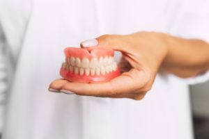 dentist holding set of dentures in Moses Lake