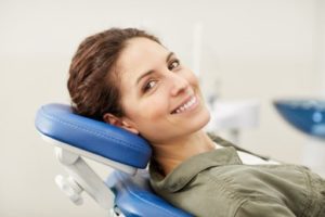 Woman leaning back in a dental chair smiling