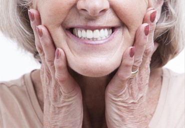 Woman smiling with her hands on her cheeks