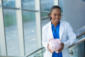 dentist in Moses Lake holding a piggy bank