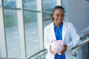 dentist in Moses Lake holding a piggy bank 