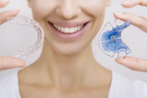 Woman holding her retainer.