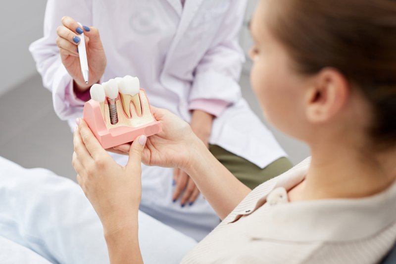 Dentist pointing to a model of dental implants
