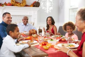 family sitting at table eating a Thanksgiving meal