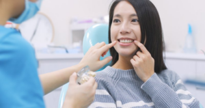 Patient pointing to her teeth and explaining to her dentist what her smile goals are