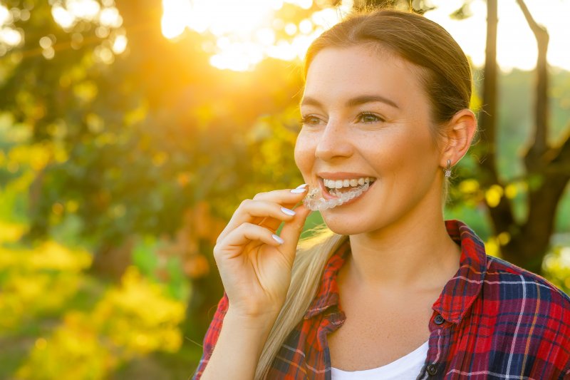 woman in the woods with her Invisalign